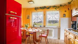 a kitchen with a table and chairs and a red refrigerator at Fewo Fuchs in Lauterbach