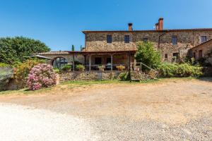 an old stone house with a yard in front of it at Agriturismo Paugnano in Radicondoli