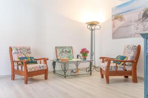 a living room with two chairs and a table at Ca sa Tia Lluisa in Santanyi