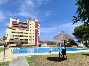 a resort with a pool and an umbrella and a building at Casa Bellota in Torrox