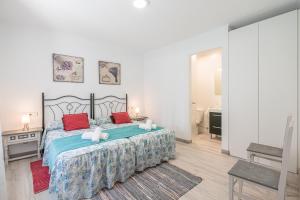 a bedroom with a large bed with red pillows at Ca sa Tia Lluisa in Santanyi