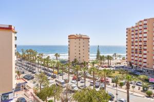 a parking lot with palm trees and buildings and the ocean at Casa Bellota in Torrox