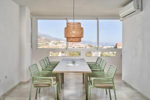 a dining room with a table and chairs and a large window at Casa Bellota in Torrox