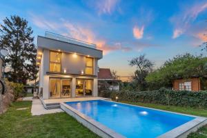 a house with a swimming pool in the yard at Villa Jäger mit Pool in Wien in Vienna