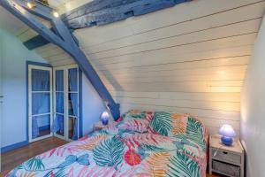 a bed with a colorful comforter in a room at Gite La Bergerie près de Lourdes in Adé