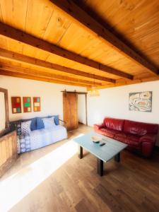 a living room with a red couch and a table at La gloria nature & relax in Puerto del Rosario