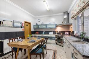 a large kitchen with a wooden table and chairs at Casa da Cidade de Loulé in Loulé