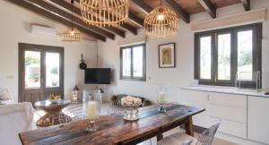a living room with a wooden table and chandeliers at Finca Sa Real in Cala Millor