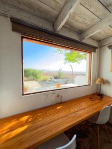 a large window in a room with a wooden desk at La gloria nature & relax in Puerto del Rosario