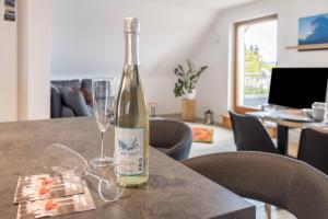 a bottle of wine sitting on a table with glasses at Über der alten Gärtnerei in Allensbach