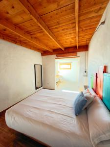 a large bed in a room with a wooden ceiling at La gloria nature & relax in Puerto del Rosario