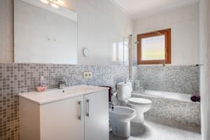 a bathroom with a sink and a toilet and a tub at Casa Mediterranea in Cala Santanyi +18 photos