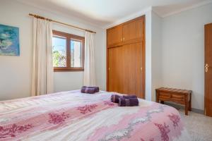 a bedroom with a bed and a wooden cabinet at Casa Mediterranea in Cala Santanyi
