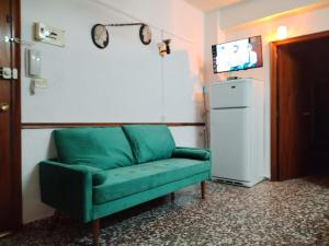 a green couch in a room with a refrigerator at Atico con doble terraza Jerica in Jérica