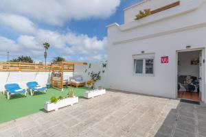 a white house with a patio with blue chairs at Apartamento Liz in Tías