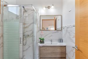 a bathroom with a shower and a sink and a mirror at Apartamento Liz in Tías +18 photos