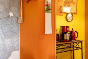an orange door in a kitchen with a table and a clock at Finnhütte Hohe Klinge Trusetal in Brotterode