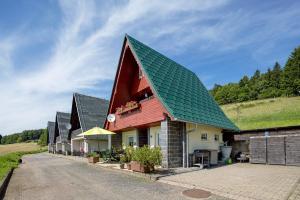 a red house with a green roof at Finnhütte Hohe Klinge Trusetal in Brotterode