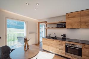 a kitchen with a table and a large window at Apartments Hofmann in Prateria