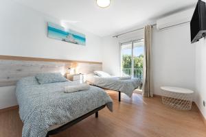 a bedroom with two beds and a large window at Apartment Mijas Sun and Beach in Sitio de Calahonda