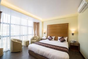 a hotel room with a bed and a large window at Hotel Thakali Inn in Kathmandu