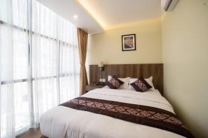 a bedroom with a large bed and a large window at Hotel Thakali Inn in Kathmandu