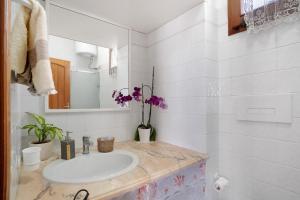 a white bathroom with a sink and a mirror at Casatullio - Sant'Angelo d'Ischia in Sant'Angelo D'Ischia +14 photos