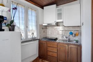 a kitchen with white cabinets and a sink at Casatullio - Sant'Angelo d'Ischia in Sant'Angelo D'Ischia
