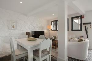a white dining room with a white table and chairs at The Village Loft in Caniço