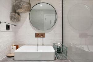 a bathroom with a white sink and a mirror at The Village Loft in Caniço +15 photos