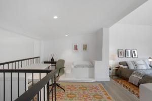 a white room with a bed and a desk in it at The Village Loft in Caniço