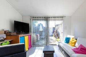 a living room with a couch and a tv at Studio Cosy Climatisé, Cap Bretron in Capbreton