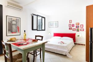 a bedroom with a table and a bed and a table and chairs at Nido in Monte Petrosu
