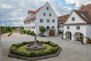 a large white building with a fountain in a courtyard at Schloss Kirchberg -Appartment Fleur in Immenstaad am Bodensee