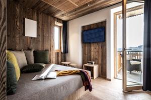 a bedroom with a bed and a balcony at Oberfallerhof Apartment Inni in Barbiano