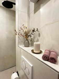 a bathroom with a white counter with a candle and towels at Fewo Sand 10 - Altstadtstudio in Bamberg