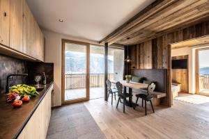 a kitchen and dining room with a table and chairs at Oberfallerhof Apartment Inni in Barbiano