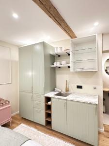 a kitchen with white cabinets and a sink at Fewo Sand 10 - Altstadtstudio in Bamberg +16 photos