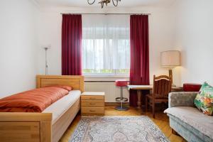 a bedroom with a bed and a couch and a window at Siravit Am See in Friedrichshafen
