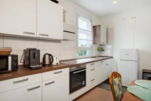 a kitchen with white cabinets and a stove top oven at Siravit Am See in Friedrichshafen