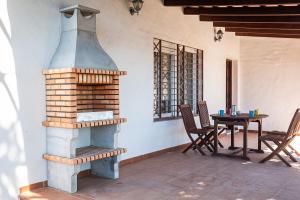 an outdoor fireplace on a patio with a table at Casa - 2 Mar y Sombra in Barbate