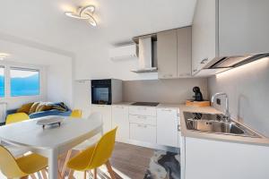 a kitchen with a sink and a table with chairs at Cà De Qualì in Costa Volpino