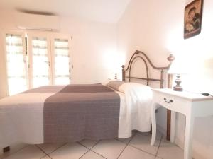 a white bedroom with a bed and a white table at Il Mirto in Marciana