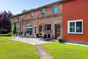 a brick building with chairs and a table in front of it at Kranichnest in Lüdershagen