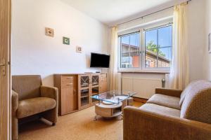 a living room with a couch and a table and a tv at Kranichnest in Lüdershagen