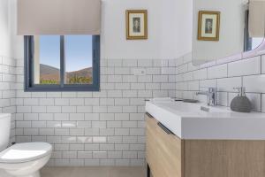 ein weißes Badezimmer mit Toilette und Waschbecken in der Unterkunft Ternemoyschool in Pájara + 19 Fotos