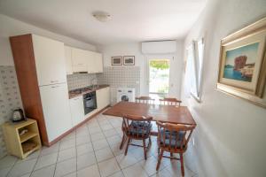 a kitchen with a wooden table and chairs at Il Mirto in Marciana