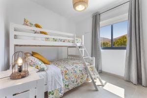ein weißes Schlafzimmer mit einem Etagenbett und einem Schreibtisch in der Unterkunft Ternemoyschool in Pájara