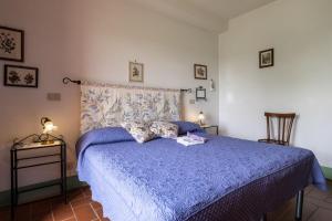 a bedroom with a blue bed with two stuffed animals on it at Appartamento Lavanda in Radicofani