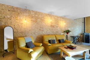 a living room with two yellow couches and a table at Logement Pascal in Villeneuve-sur-Lot